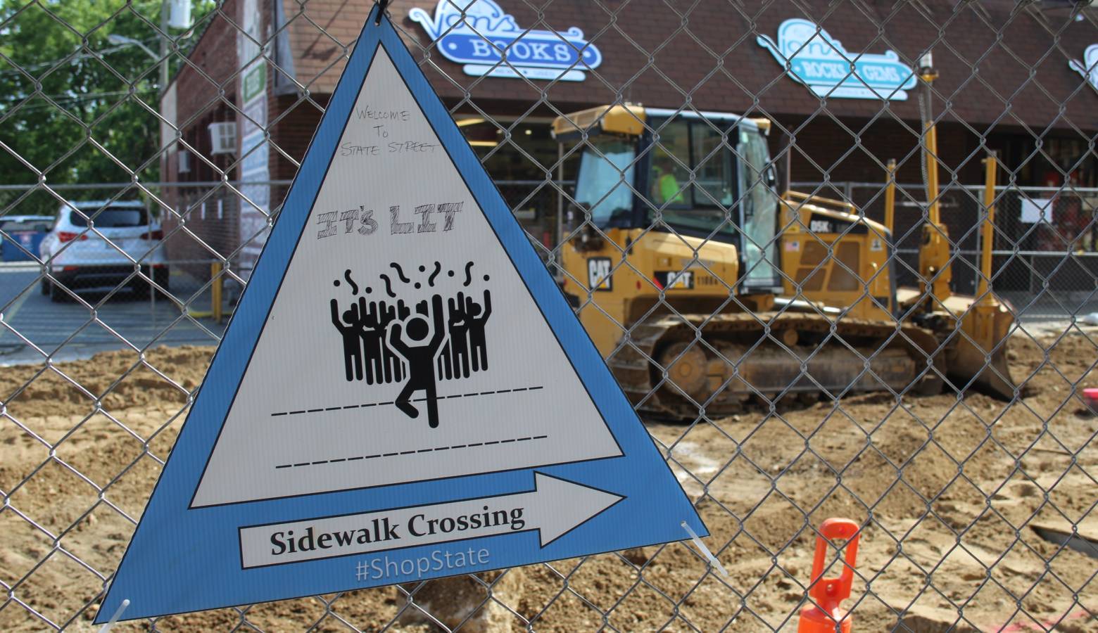 A sign telling pedestrians how to cross construction to access local businesses got some original artwork along West Lafayette's State Street. (Annie Ropeik/IPB News)