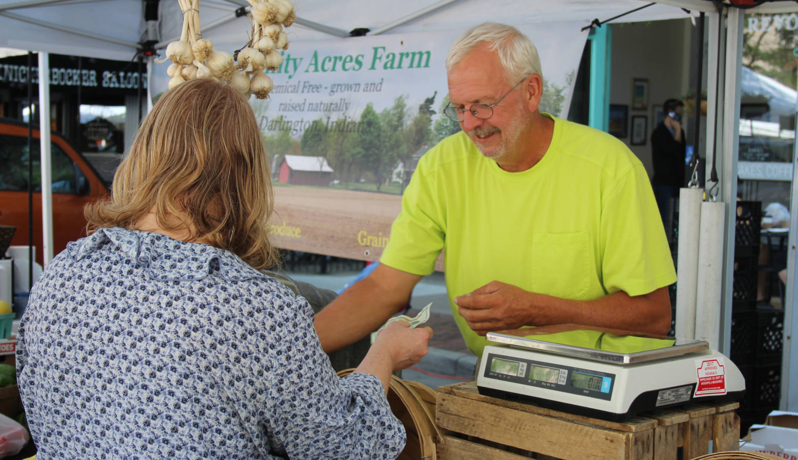 Montgomery County-based grower Gary Cox makes change for a customer in his Trinity Acres Farm tent at the Lafayette Farmers Market. (Annie Ropeik/IPB News)