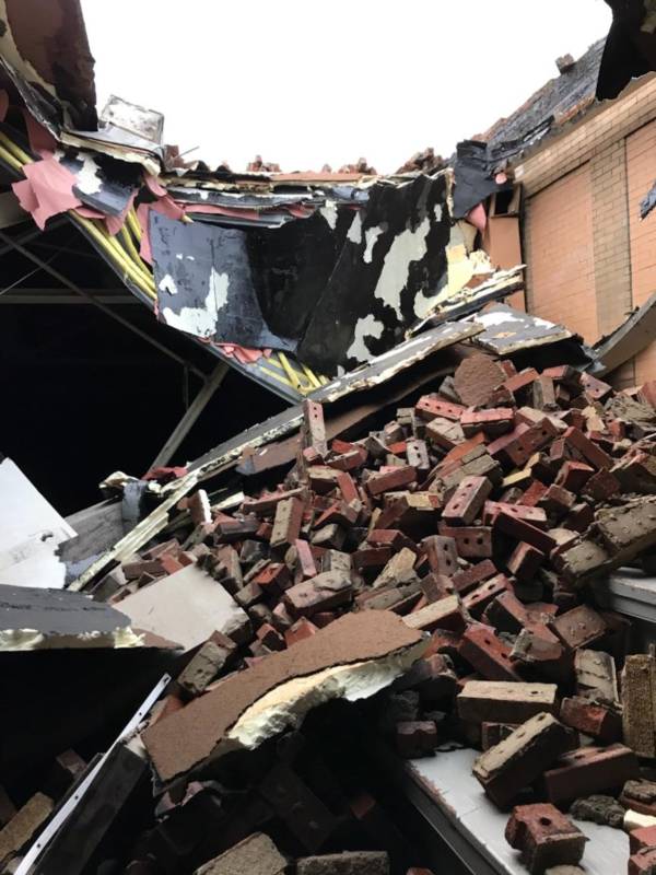 Tornado damage at the Fieldhouse includes a large hole in its roof.