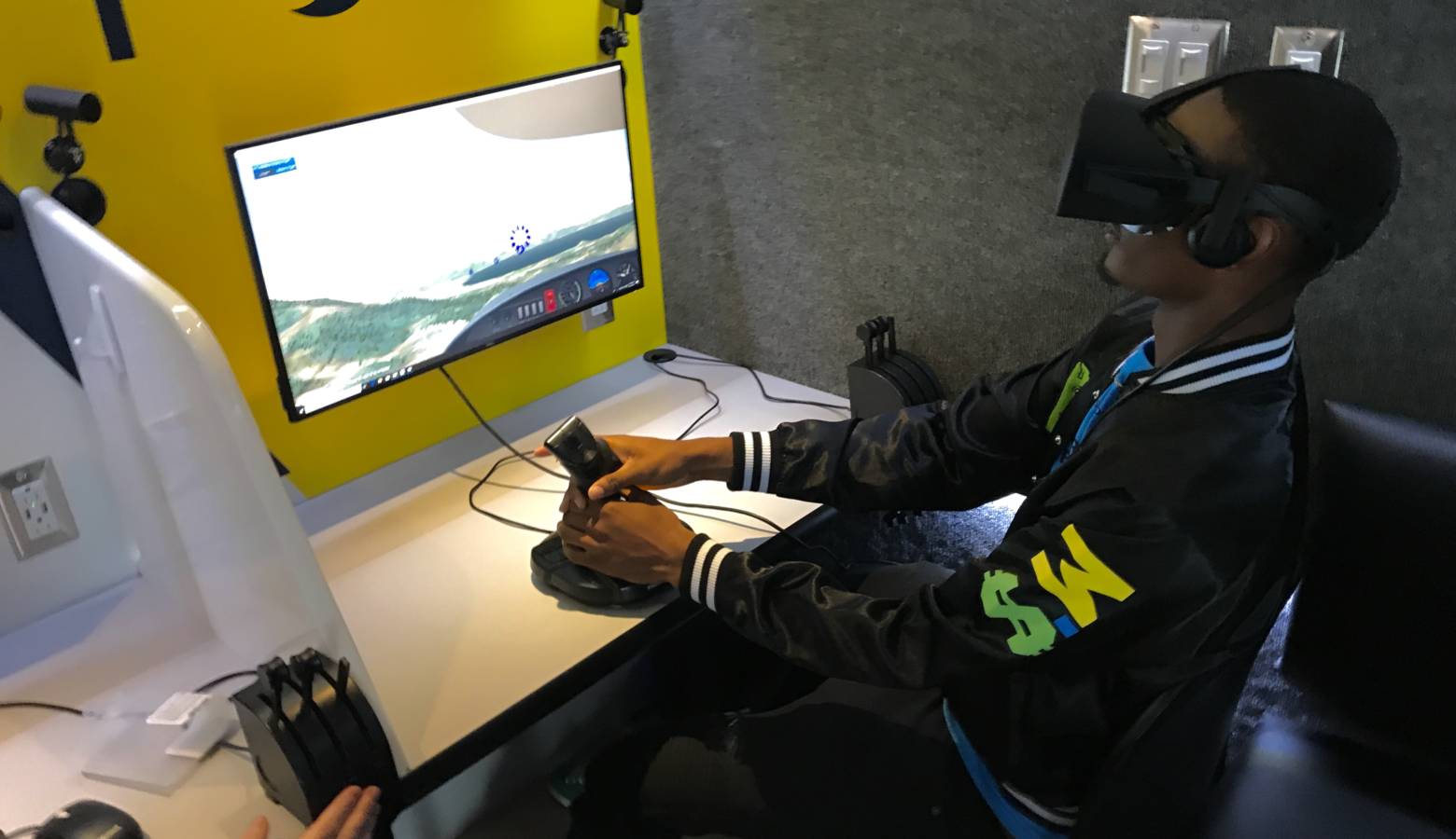 A high school student tries LIFT Academy's flight simulator at a career fair in Indianapolis. (Justin Hicks/IPB News)