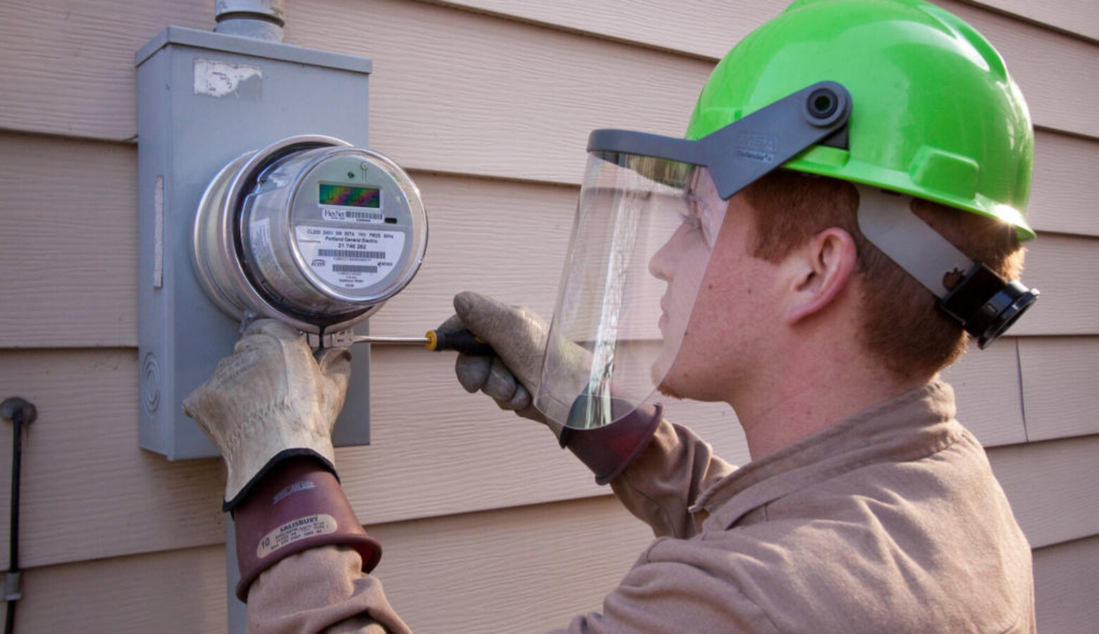 An employee of Wellington Energy Inc. works to install a new watthour meter at a residence in Portland, Oregon. (Portland General Electric)