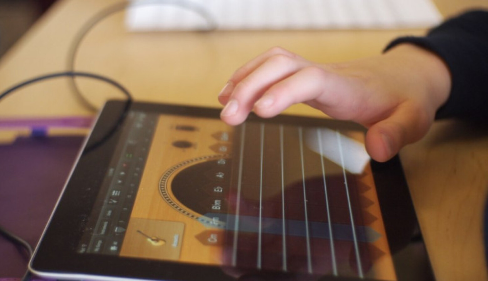 A student touches an iPad with his hand.