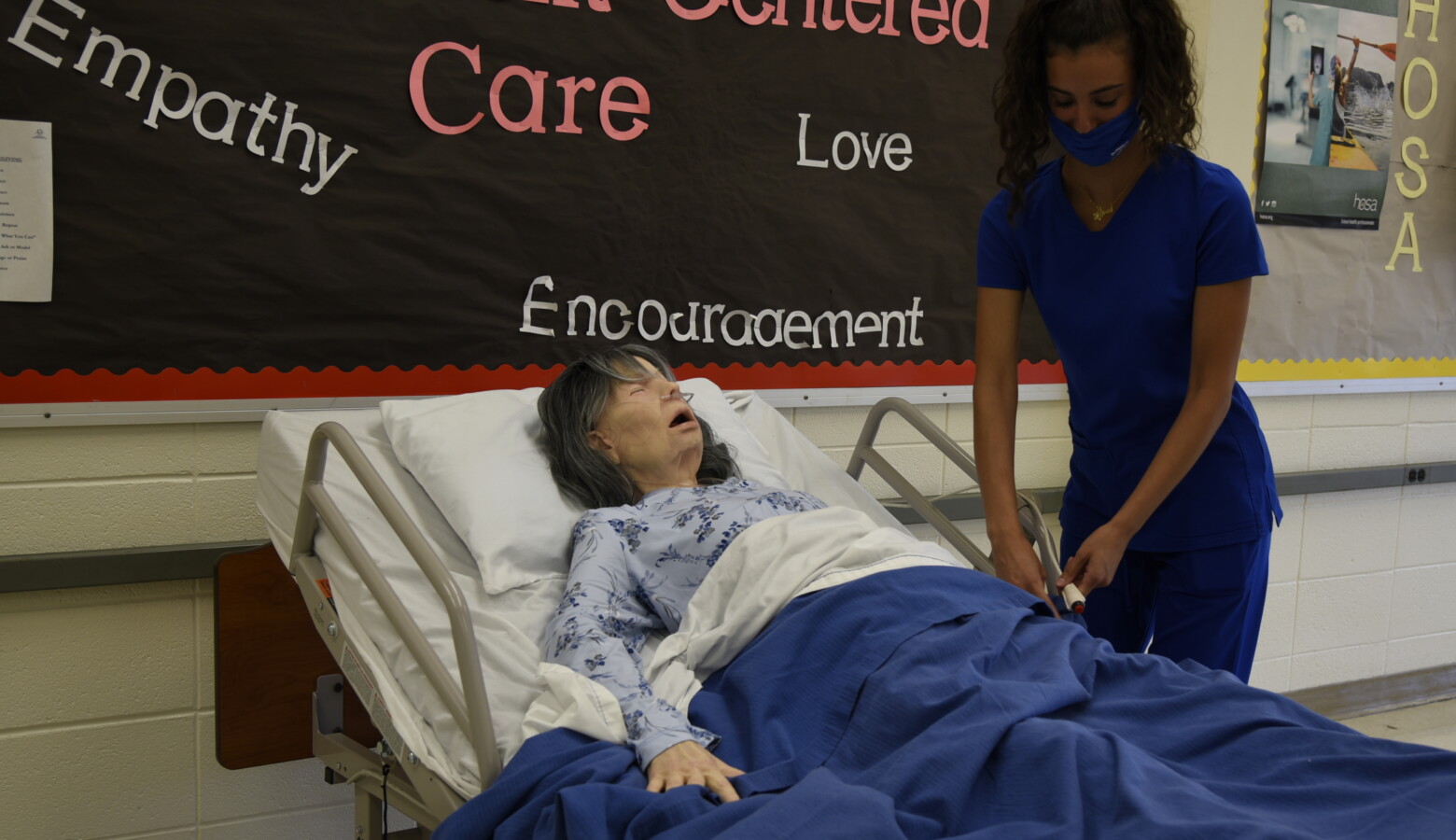 Andrea Zaknoun, a CTE student at A.K. Smith Career Center studying to become a certified nursing assistant, practices on a mannequin in a classroom during a Summer Bridge program. (Justin Hicks/IPB News)