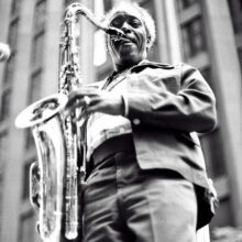 Jazz saxophone player Sonny Stitt playing the saxophone in front of a city building.