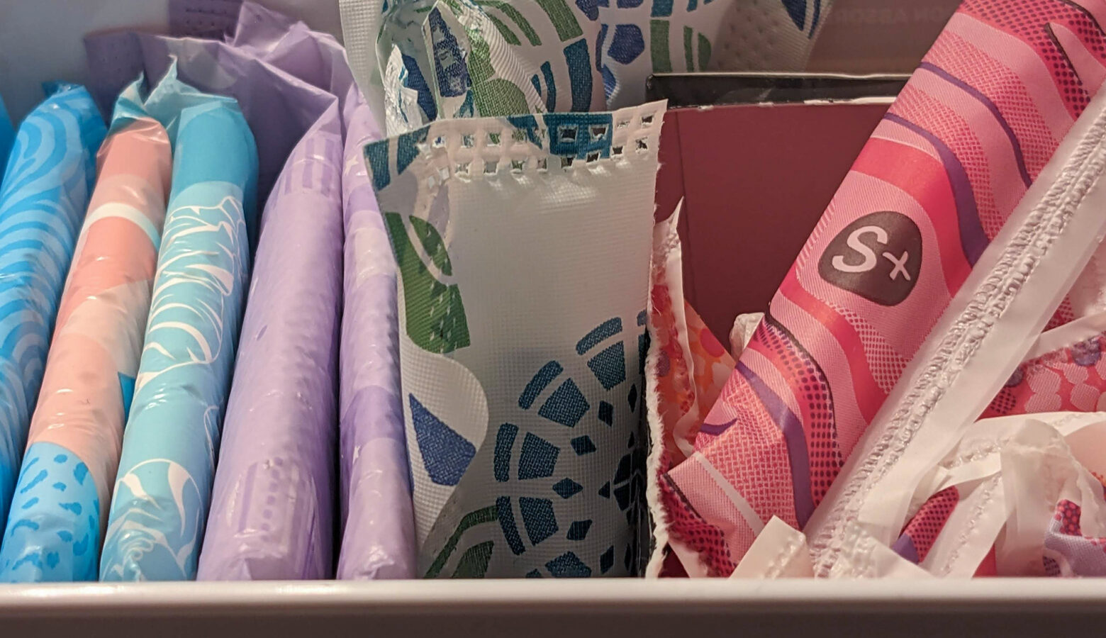 A box full of wrapped tampons and menstruation pads.