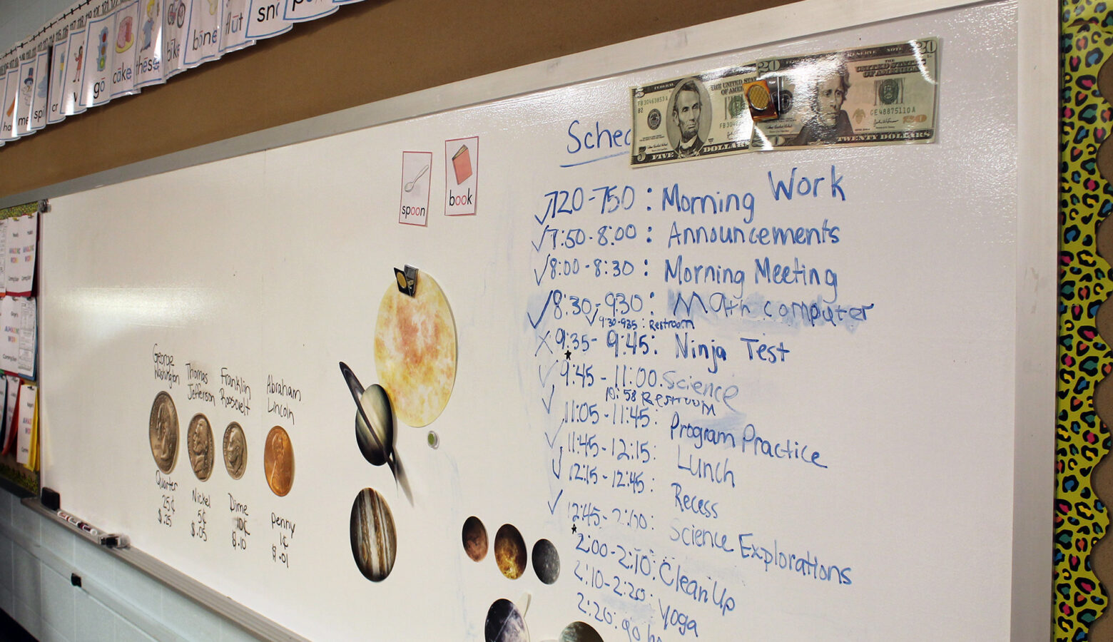 A classroom white board shows a class schedule.