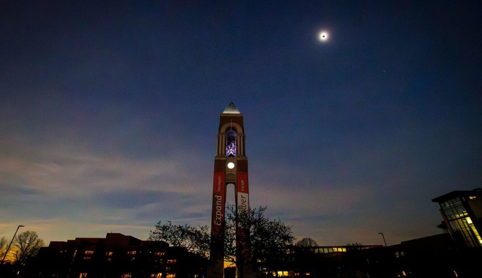 The Ball State bell tower is seen during the total solar eclipse, as the sky darkens like it's night at 3 PM.