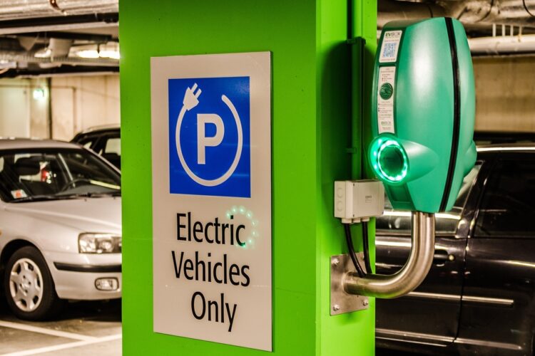 A charging station for electric vehicles inside a parking garage with a sign that reads "electric vehicles only."