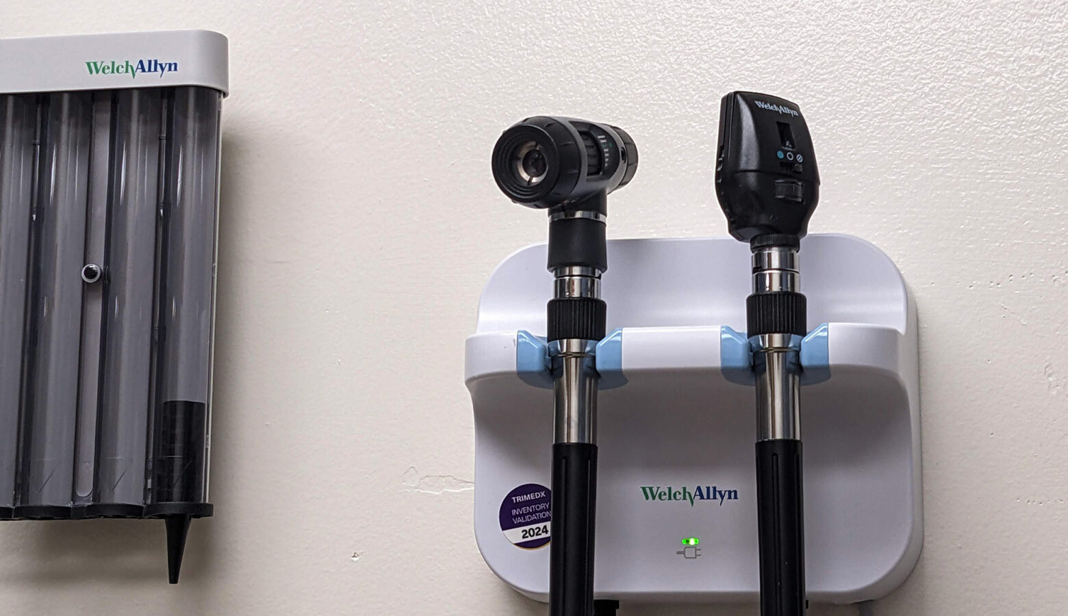 Medical instruments affixed to a white wall in an exam room.