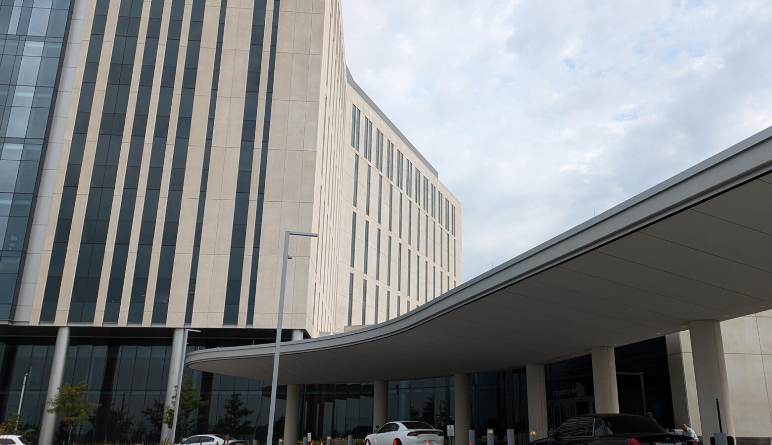 The exterior of the Marion County Justice Campus. A large limestone building stands over a carport.