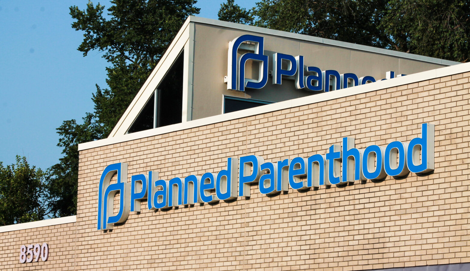 The exterior of a Planned Parenthood clinic. It is a tan brick building with the organization's logo on the outside.