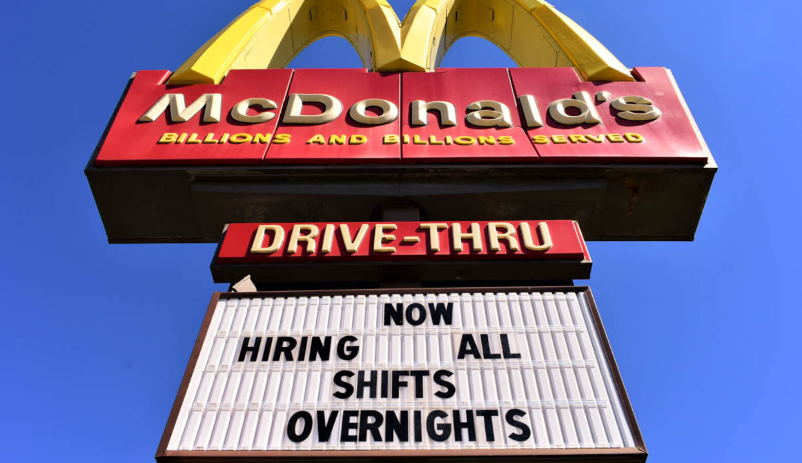 A McDonald's sign includes the message, Now Hiring All Shifts Overnights