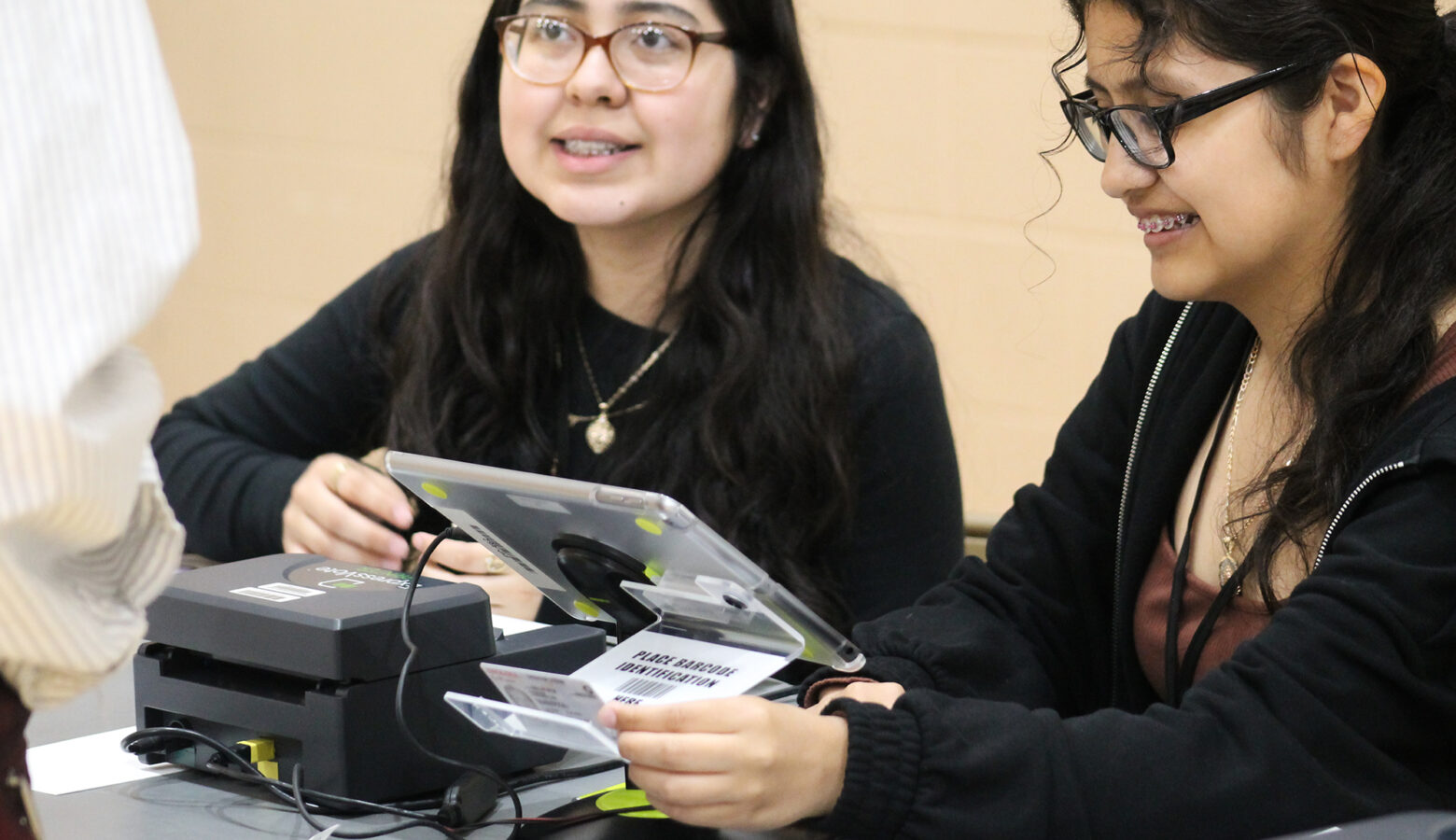 Two high school students check an ID.