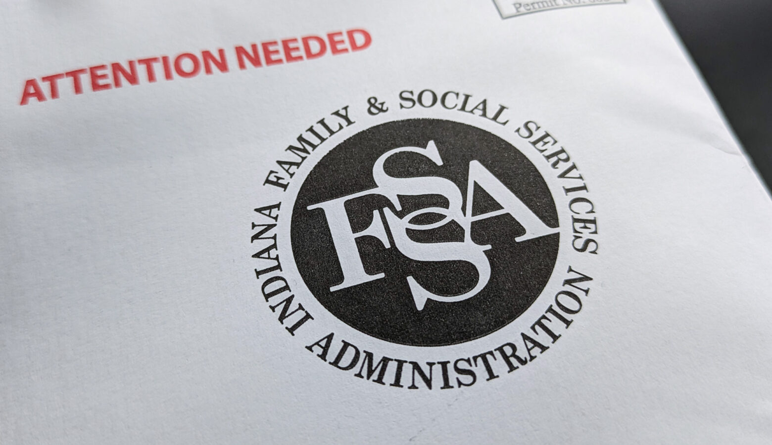 An envelope with the Indiana Family and Social Services logo printed in black and the words "Attention needed" in red.