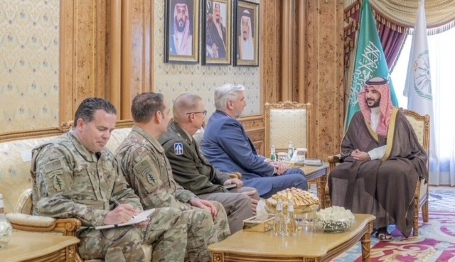 Eric Holcomb and Indiana National Guard officials sit on a couch, facing a Saudi Arabian official sitting on a chair.