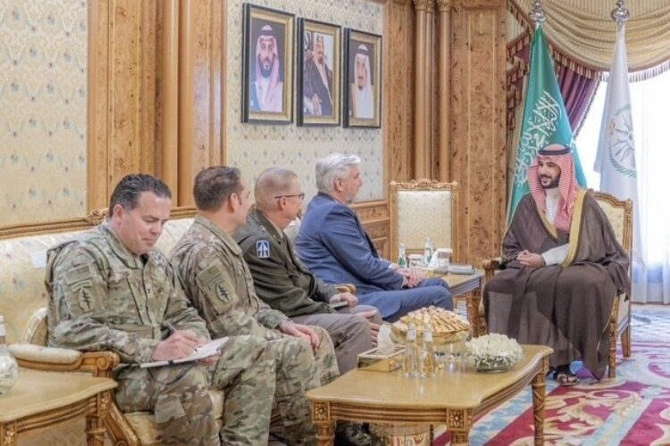 Eric Holcomb and Indiana National Guard officials sit on a couch, facing a Saudi Arabian official sitting on a chair.