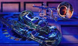 A saxophone and trumpet lay on a table with a dark blue light shining on them.