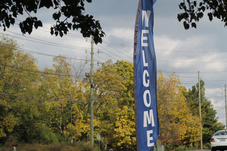 A banner with Welcome written down its length flaps in the wind in the fall.