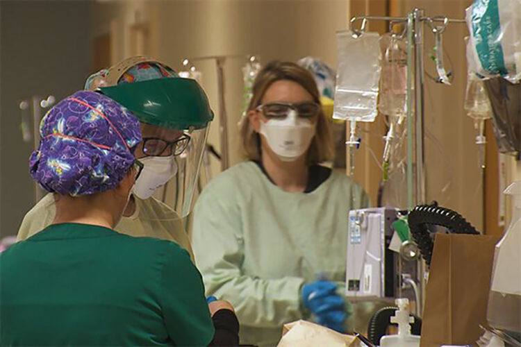 A medical team transports a patient down a hallway in a hospital.