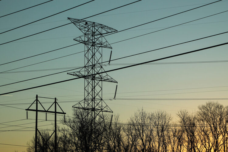 A photo of power lines near an airport at dusk.