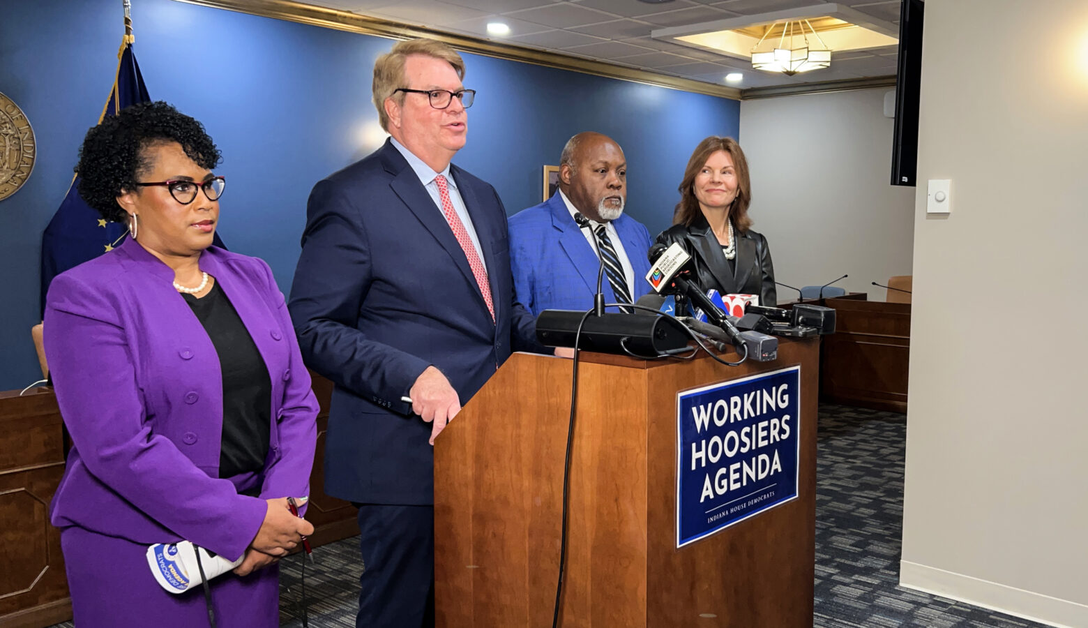 House Democratic leaders stand next to each other in a line in front of a lectern.