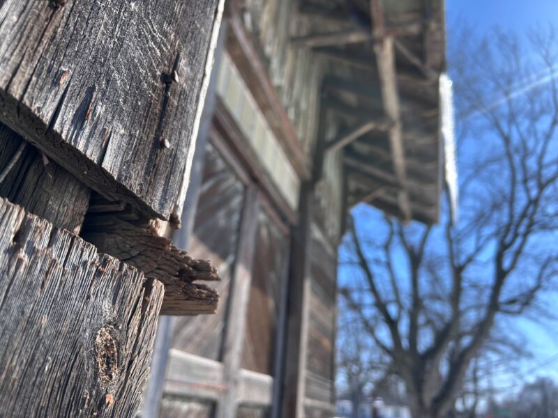 An up close look at rotting wood planks that are part of a larger building.