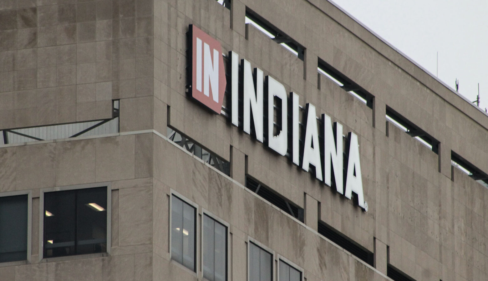 A tall brown building has a sign that reads "IN INDIANA" in the top left corner of it.