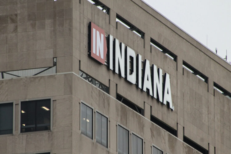 A tall brown building has a sign that reads "IN INDIANA" in the top left corner of it.