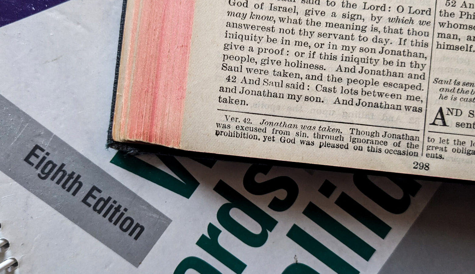 A Bible sits on top of a grammar textbook.