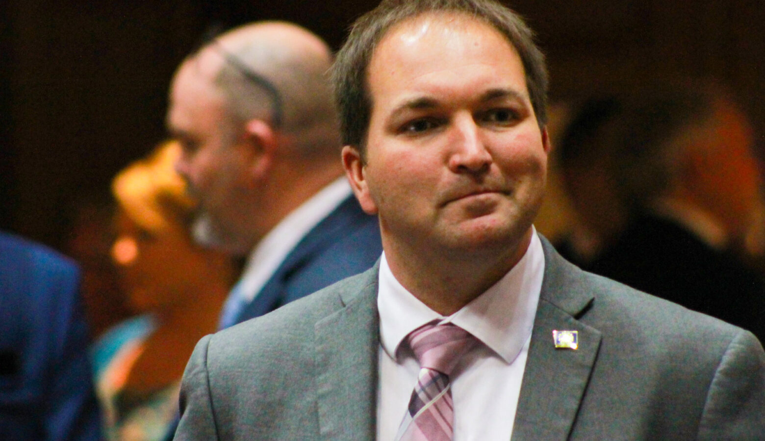 J.D. Prescott is a White man with brown hair. He is wearing a suit and tie.