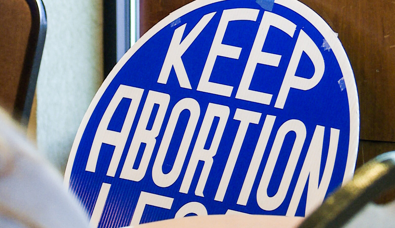 A blue, circular sign that says "Keep abortion legal" in white, block lettering.