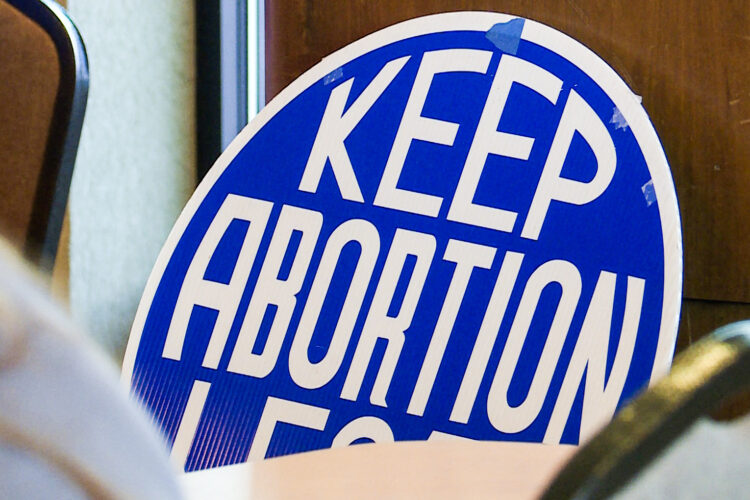 A blue, circular sign that says "Keep abortion legal" in white, block lettering.