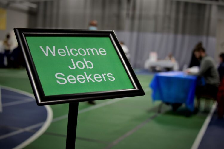 There is a black stand with a green sign inside that says "Welcome Job Seekers" in white letters.