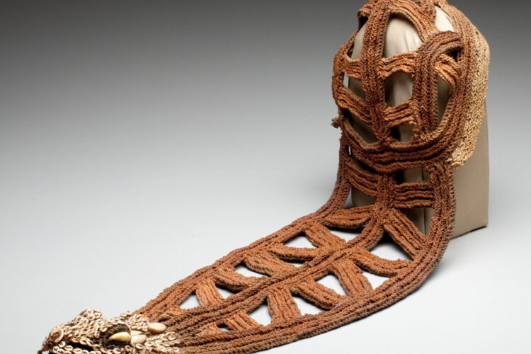 Woven Iatmul bridal headpiece from Papua New Guinea, made of plant fibers and shells, featuring a crocodile-shaped design and open triangular patterns.