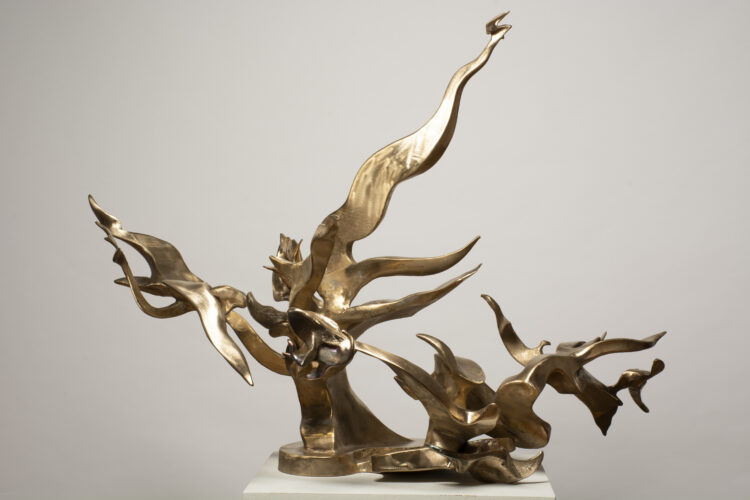 Bronze sculpture Daphne’s Defense by Richard Hunt, featuring a tree-like abstract form with hand-scribed textures, resting on an irregular bronze base and glowing with natural light.