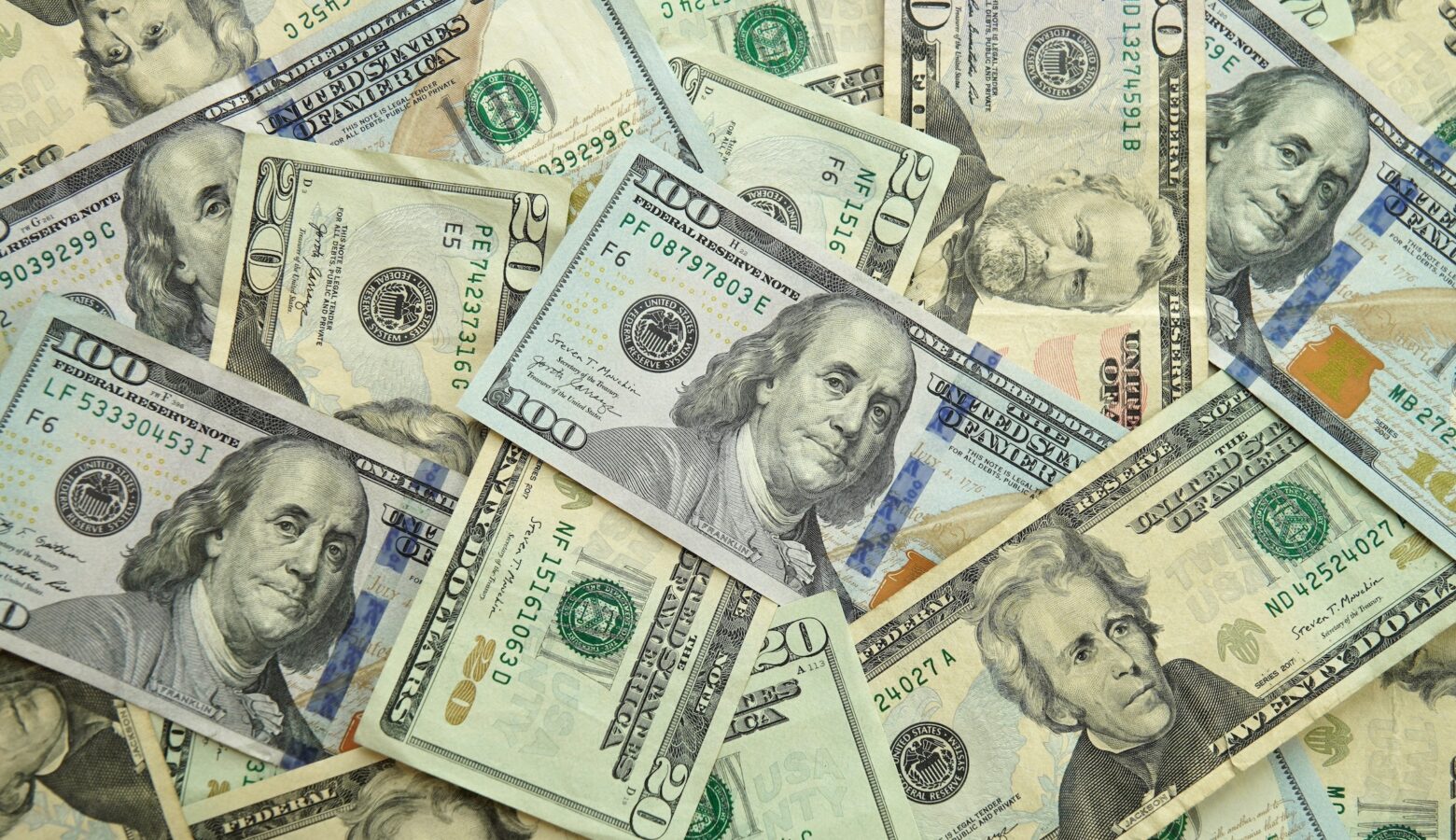 Various denominations of paper money are laid out in a pile.