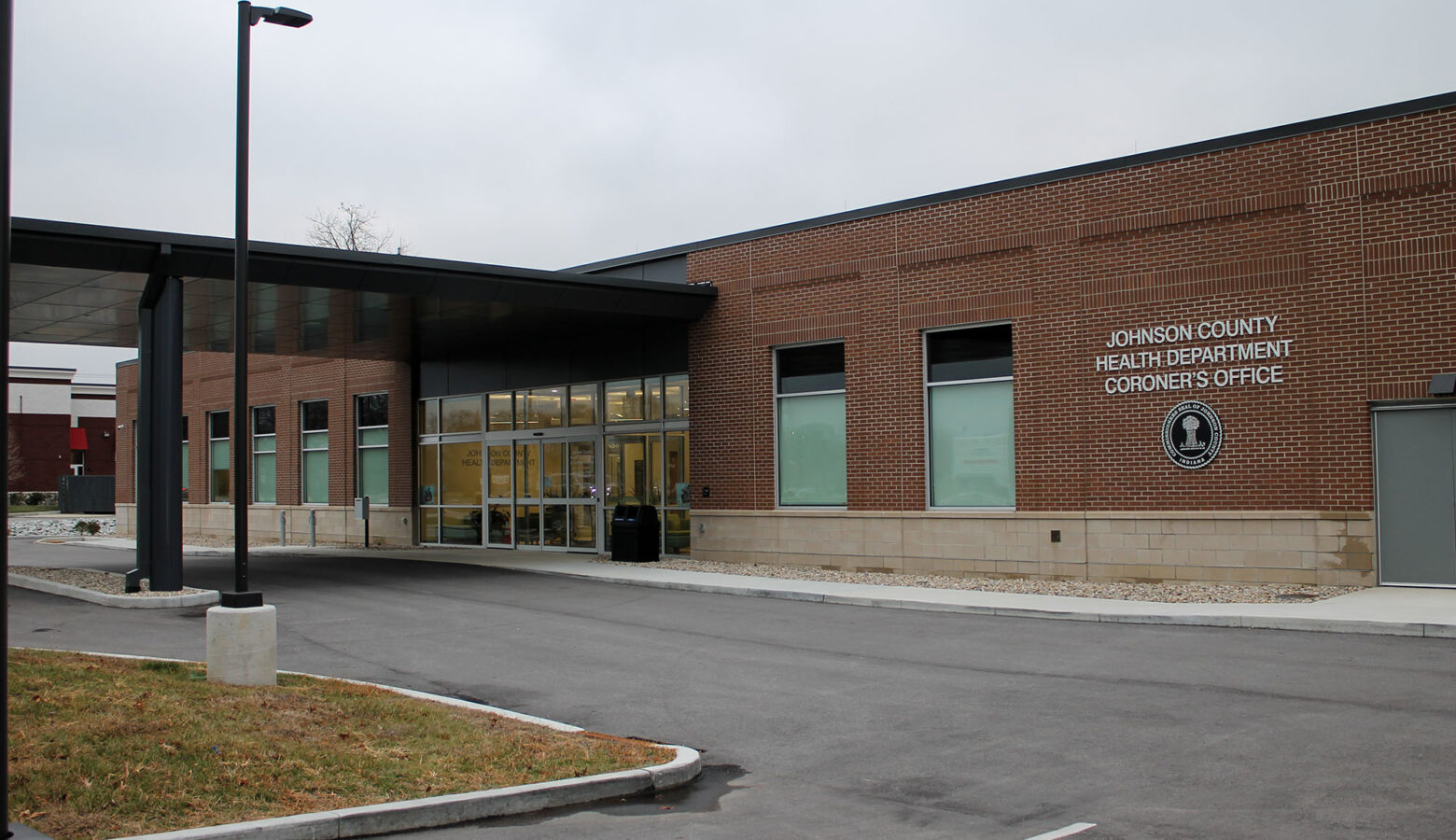 The front entrance of the Johnson County Health Department and Coroner's Office on a cloudy day.