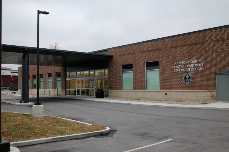 The front entrance of the Johnson County Health Department and Coroner's Office on a cloudy day.