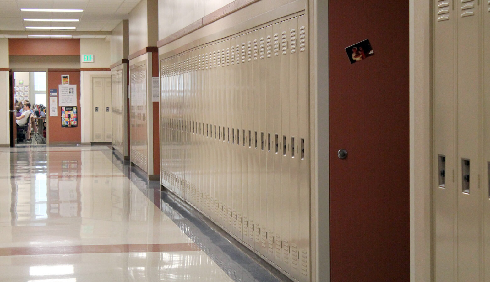 A row of tan lockers in a high school hallway.