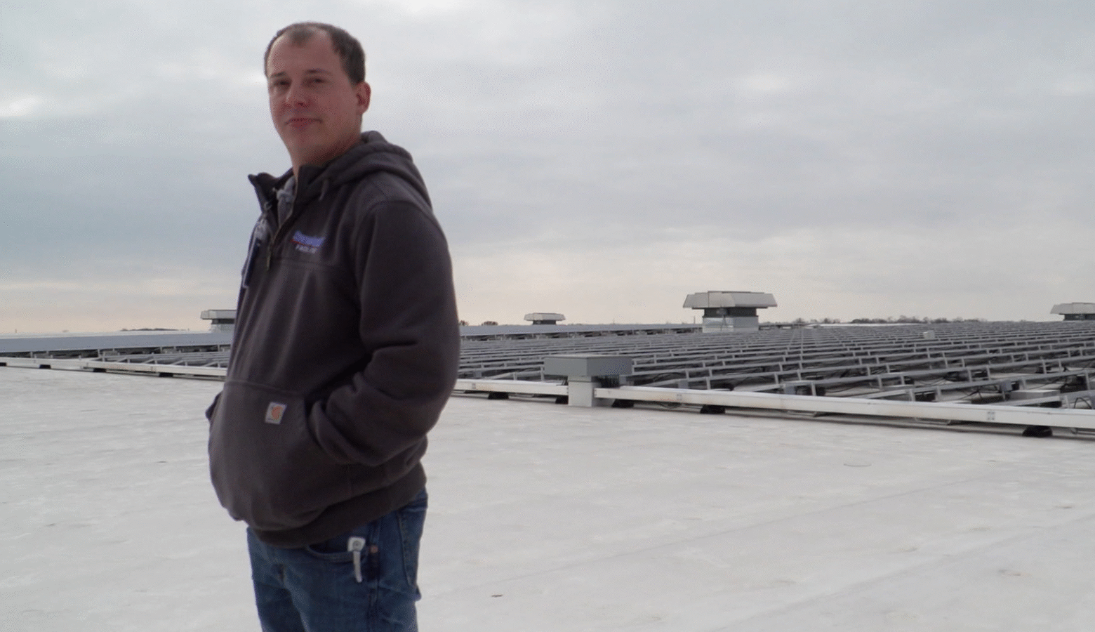 Tyler Gerardot stands in front of the solar array he helps maintain on top of Sweetwater Sound's distribution center in Fort Wayne.