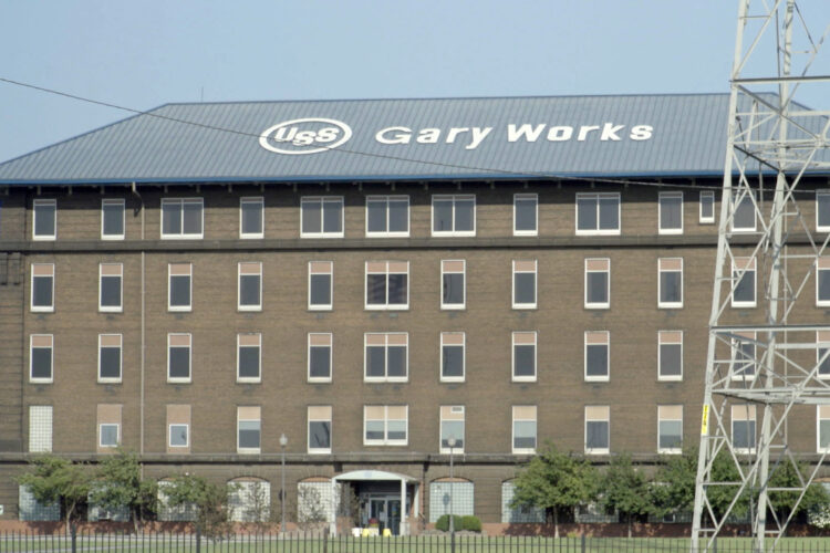 A building at U.S. Steel's Gary Works facility. It's a brown building with a blue roof that has the company's logo on it and a lot of windows.