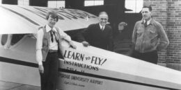 A historic photo showing pilot Amelia Earhart with two men at Purdue University in 1936. They stand next to a plane.