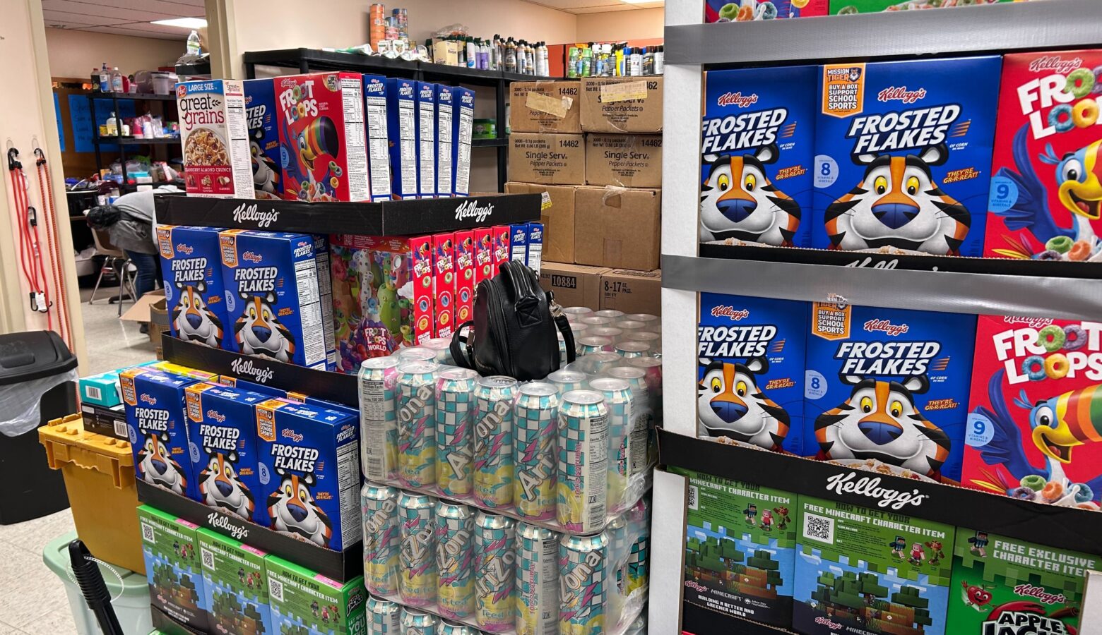 A variety of foods are stacked on a pallet almost reaching the roof of the room.