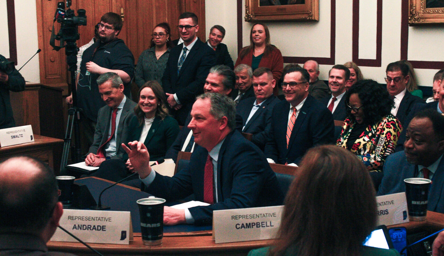 Todd Huston is surrounded by a crowd at a Statehouse meeting room.