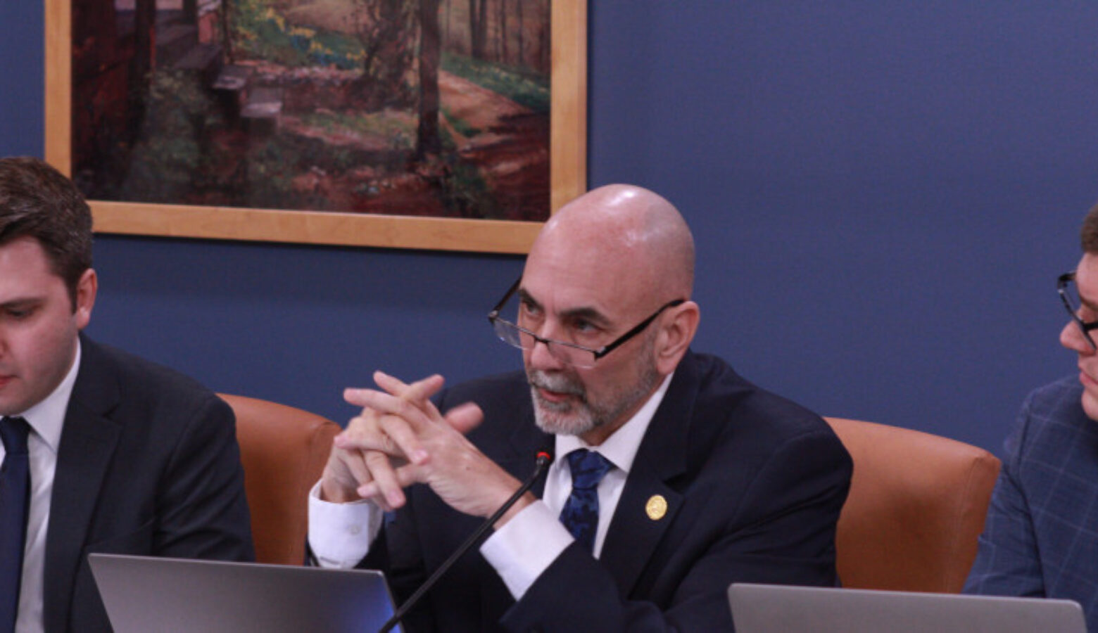 Rep. Steve Bartels (R-Eckerty) moved to add an amendment to the bill regulating hemp aimed at protecting some industry players. He is wearing a suit with tie and is flanked by two other lawmakers seated at a table in a conference room.