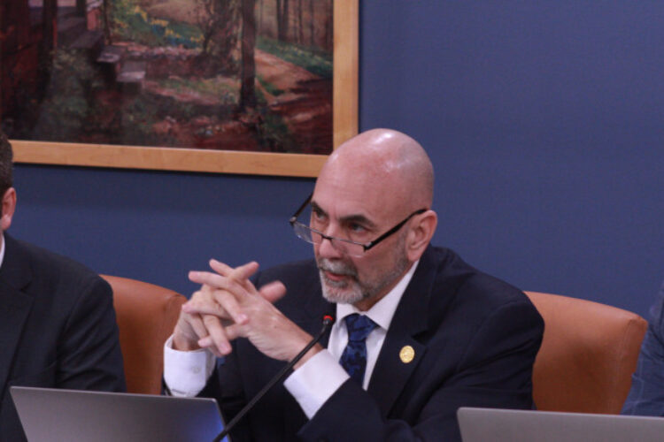 Rep. Steve Bartels (R-Eckerty) moved to add an amendment to the bill regulating hemp aimed at protecting some industry players. He is wearing a suit with tie and is flanked by two other lawmakers seated at a table in a conference room.