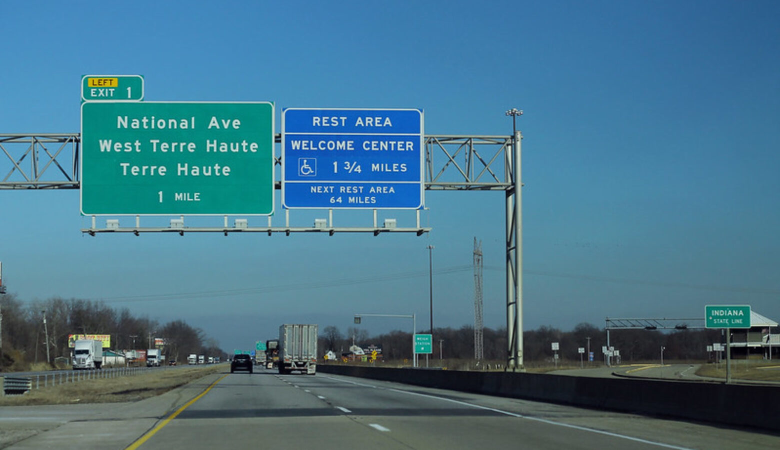 Blue and green signs welcome people to West Terre Haute, Terre Haute, and a Welcome Center Rest Area in Indiana.