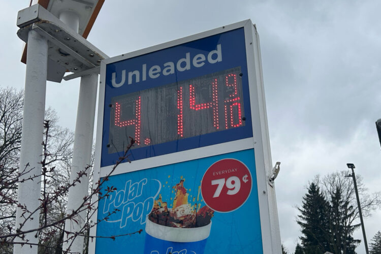 A gas station sign lists the price of unleaded gas as $4.14.