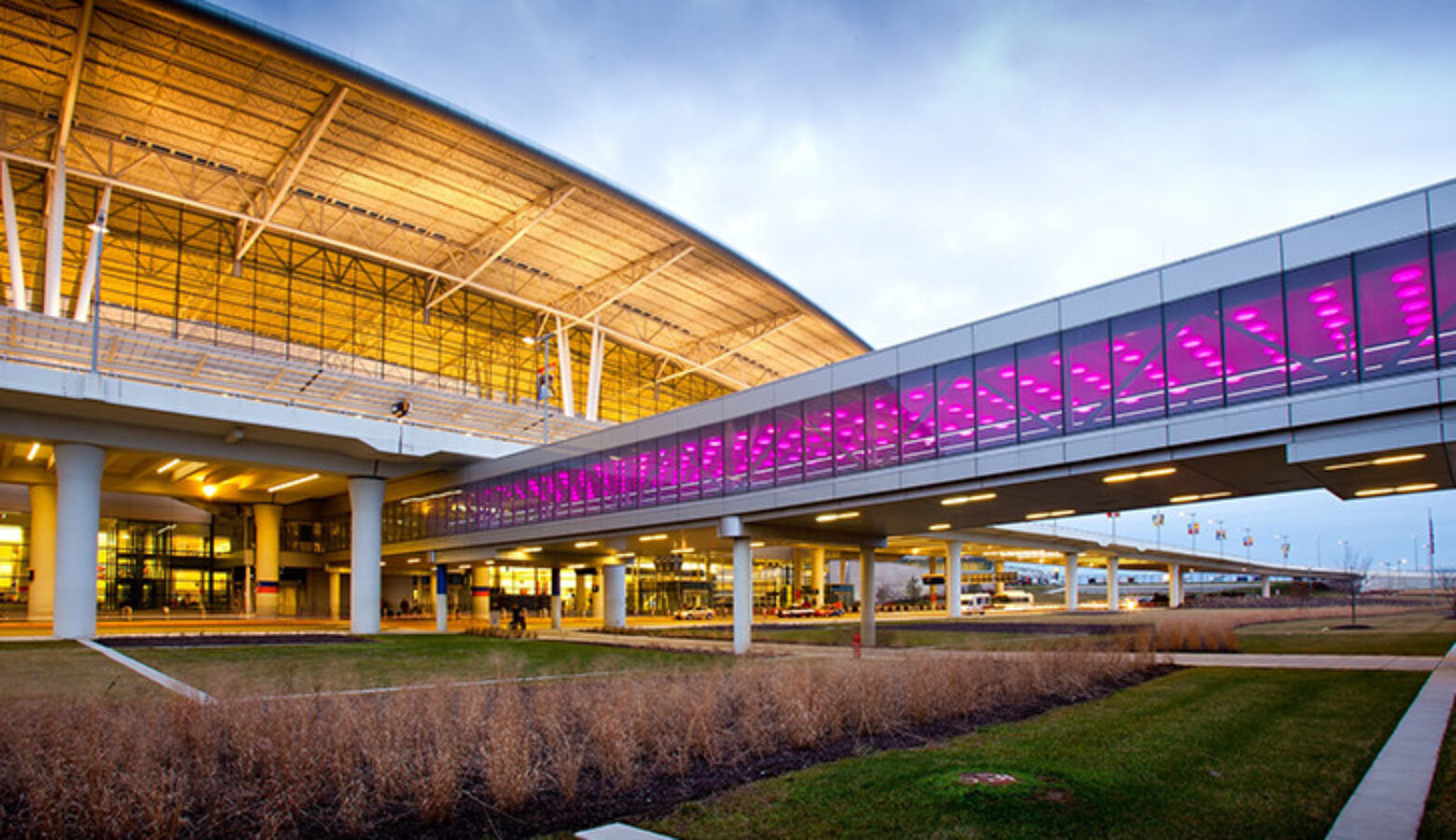 An exterior view of the front of the Indianapolis International Airport Terminal including the enclosed walkway from the airport's parking garage.