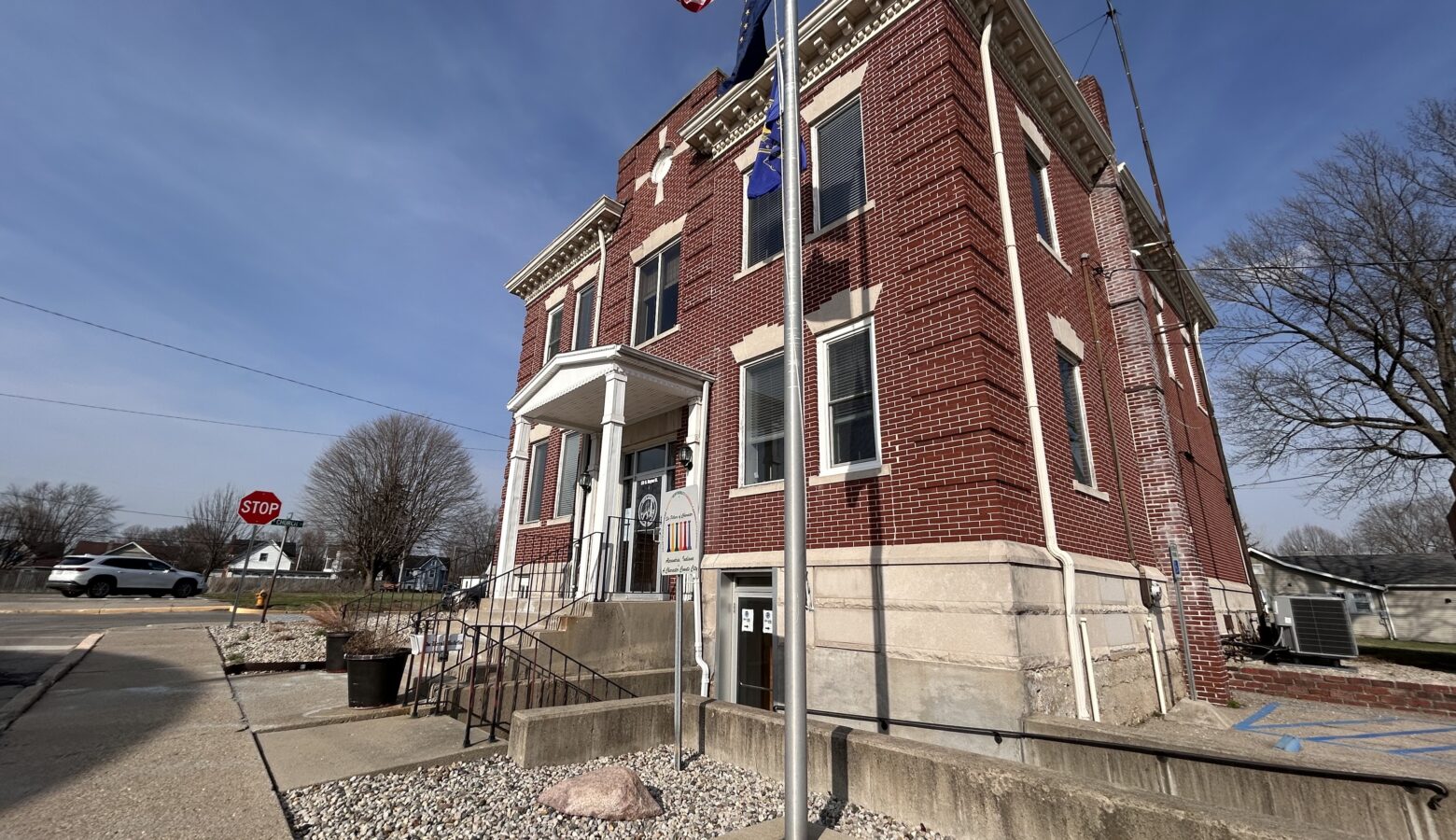 A two story brick building stands with a blue sky behind it